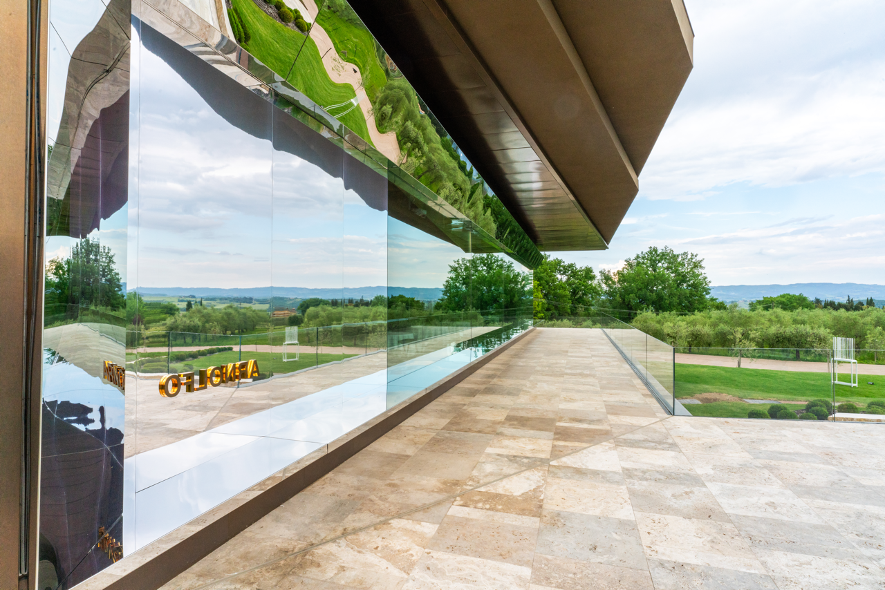 Esterno del ristorante Arnolfo con architettura contemporanea e vista sulle colline toscane